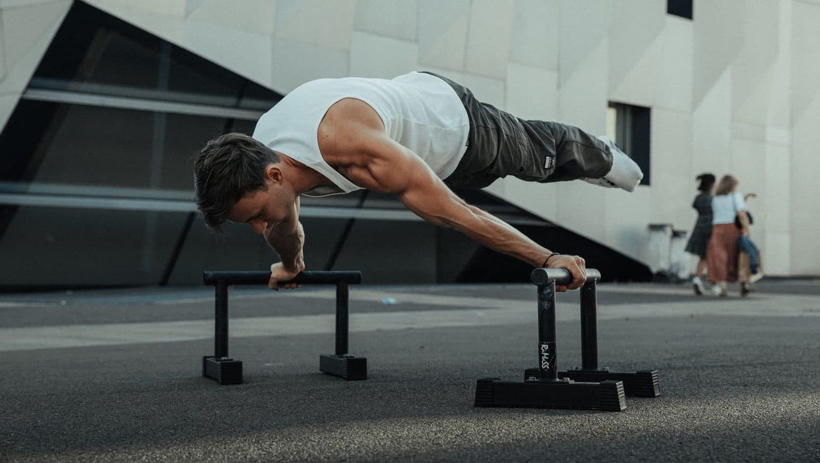 Atleta ejecutando una plancha sobre paralelas en un entrenamiento de calistenia