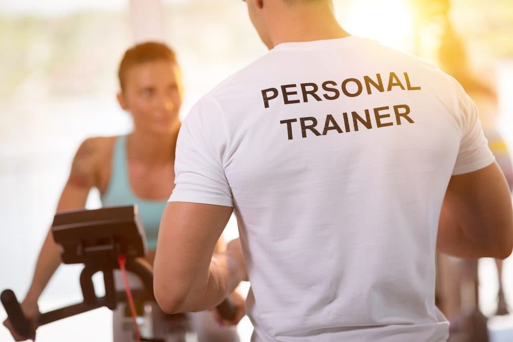 Entrenador de NovaFit guiando a una clienta durante una sesión de entrenamiento personal en el gimnasio