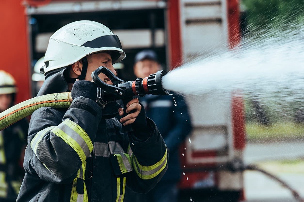Bombero manejando una manguera durante una prueba física de oposición
