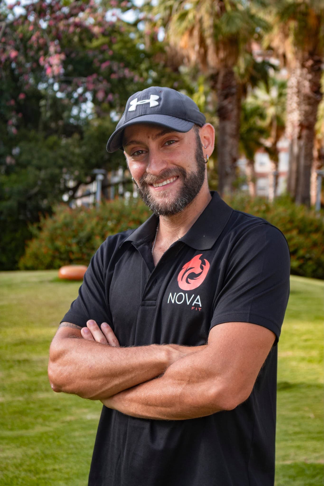 Javier Romero, entrenador personal de NovaFit, con el polo de la marca y los brazos cruzados